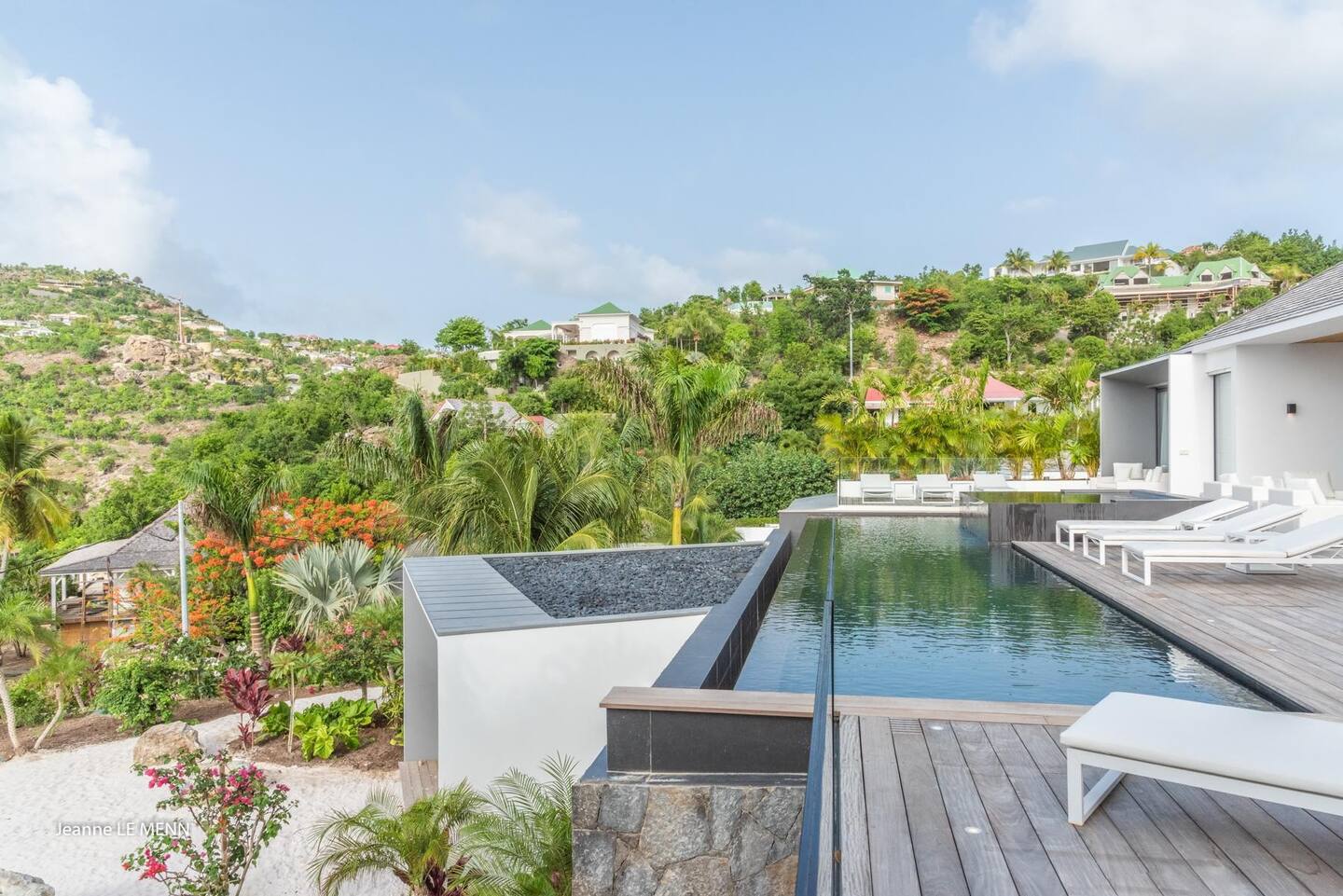 The patio has a heated infinity pool, a Jacuzzi, and plenty of lounge seats.