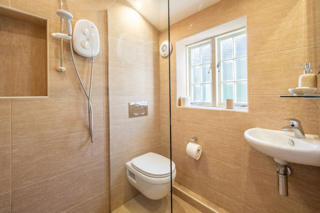 A contemporary wet room with a shower, wash basin, and WC.