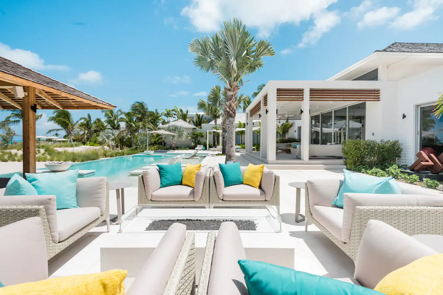 Serenely landscaped outdoor pool area with plush sofas for a relaxing day/night out.