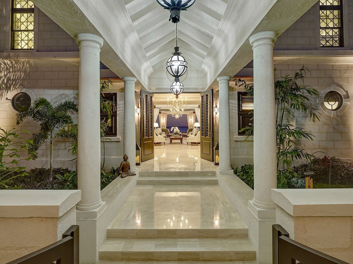 A lavish entrance hallway with high ceilings, marble flooring, and exquisite lightings, creating an atmosphere of opulence and elegance.